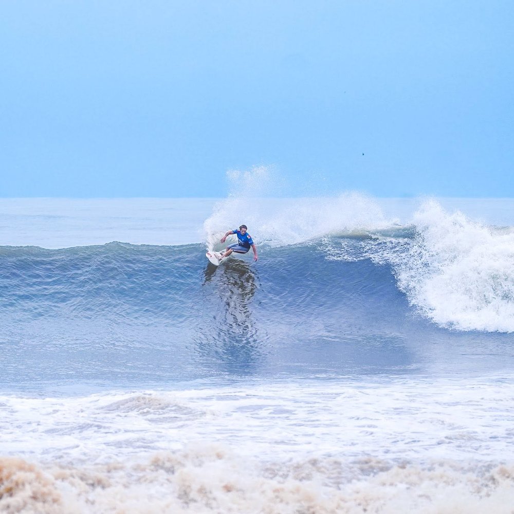 A surfer carving a wave on El Salvador's Pacific coast
